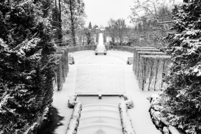 Schloss und Schlossgarten Schwetzingen - Garten - Naturtheater - Von Westen - Blick vom erhöhten Tempel des Apoll nach Osten und nach unten auf das Naturtheater bei Schneefall; vorne unten die Kaskaden mit den beidseitigen Treppen, dahinter die Bühne mit durch Hecken angedeutete Proszenien, darunter der tiefer gelegene Zuschauerraum, zugänglich mittels dreier Treppen (geschmückt mit Sphingen, verdeckt durch Wintereinhausungen (aufgenommen im Januar 2024, um die Mittagszeit)