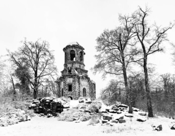 Schloss und Schlossgarten Schwetzingen - Garten - Merkurtempel - Von außen - Von Süden - Blick nach Norden auf den als Ruine gebauten Merkurtempel im Schneefall; links unterhalb das Felsenmeer mit dem Eingang zum unterirdischen Gewölbe (Architekt: Nicolas de Pigage (1723-1796); Bauzeit: 1784-1792, Restaurierung: 2008–2013; Abmessungen: Grundfläche des Sechsecks Länge x Breite ca. 14 x 12 Meter, Länge konkave Portalseiten ca. 10 Meter, Tiefe Kabinettseiten ca. 3,5 Meter, Durchmesser Tambour ca. 6,5 Meter, Höhe ca. 25 Meter, 4 Geschosse) (aufgenommen im Januar 2024, am frühen Nachmittag)