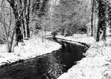 Schloss und Schlossgarten Schwetzingen - Garten - Kanal - Vor Mündung in den Moscheeweiher - Von Osten - Blick nach Westen auf den Kanal kurz vor der Einmündung in den Moscheeweiher im Schnee; rechts das südwestliche Toilettenhaus (aufgenommen im Januar 2024, am Nachmittag)