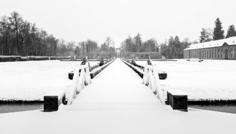 Schloss und Schlossgarten Schwetzingen - Garten - Orangeriegarten - Mittelachse Ost-West - Von Osten - Blick nach Westen auf den Organgeriegarten bei Schneefall; mittig die Ost-West-Achse und der Apollotempel, rechts die Neue Orangerie (aufgenommen im Januar 2024, um die Mittagszeit)