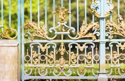 Schloss und Schlossgarten Schwetzingen - Garten - Arboretum - Südliches Tor - Von Süden - Blick auf vergoldete Rokoko-Verzierungen (Eisentür fertiggestellt 1755; entworfen von Franz Wilhelm Rabaliatti, geschmiedet von den Mannheimer Schlossermeistern Strickling und Frockmann; ursprünglich an einem anderen Ort verbaut) (aufgenommen im April 2024, um die Mittagszeit)