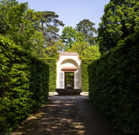 Schloss und Schlossgarten Schwetzingen - Garten - Porzellanhaus / Wasserglocke - Von außen- Von Süden - Blick von der Querachse des Naturtheaters auf die Wasserglocke (den Brunnen) sowie auf das Porzellanhaus (Porzellanhaus: Grundfläche ca. 9 x 9 Meter; Bauzeit: 1762-1764; Architekt: Nicolas de Pigage) (aufgenommen im April 2024, um die Mittagszeit)