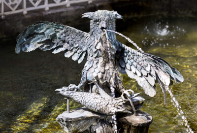 Schloss und Schlossgarten Schwetzingen - Garten - Wasserspeiende Vögel - Bassin - Von Südost - Blick in das Bassin, in der Mitte die Skulptur eines Uhus auf einem Holzstumpf, in den Fängen ein toter Fasan (Originale Skulptur: Herkunft vermutlich von Schloss La Malgrange bei Nancy, Datierung wohl um 1740, Kunstschmied unbekannt, Material / Fassung aus Eisenblech mit realistischer Bemalung; Kopie: um 1933 kopiert, 1995 erneut kopiert von Friedhelm Pankowski (*1946), nun mittels Kupferblech) (aufgenommen im April 2024, am Nachmittag)