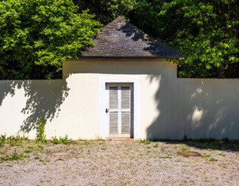 Schloss und Schlossgarten Schwetzingen - Garten - Fasanenhof - Von Süden - Blick auf das nördliche Fasanenbruthaus, fensterlos zum Hof hin, Südwand in Umfassungsmauer des Hofes übergehend; gebrütet und gezüchtet wurden Fasane zum Aussetzen bei Jagden (Hof: Länge x Breite (ohne Bruthäuser) ca. 18 Meter x 14 Meter; Bauzeit: zwischen 1763 und 1767 (gleichzeitig mit der ehemaligen Menagerie); Architekt: Nicolas de Pigage) (aufgenommen im Mai 2024, um die Mittagszeit)