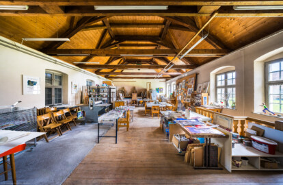 Schloss und Schlossgarten Schwetzingen - Garten - Invalidenkaserne (ehemaliges Baumagazin) / xylon - Museum + Werkstätten - Nordflügel - Von innen - Von Westen - Blick nach Osten in die große Werkstatt und den Dachstuhl (Vierflügelanlage: Länge x Breite: ca. 60 x 50 Meter; Nordflügel: ca. 30 x 10 Meter; Bauzeit: um 1774; Architekt des Baummagazins: Nicolas de Pigage; Umbau zur Kaserne: Ingenieur-Oberst von Pfister) (aufgenommen im Juni 2024, am Nachmittag) Schloss und Schlossgarten Schwetzingen - Garten - Invalidenkaserne (ehemaliges Baumagazin) / xylon - Museum + Werkstätten - Nordflügel - Von innen - Von Westen - Blick nach Osten in die große Werkstatt und den Dachstuhl (Vierflügelanlage: Länge x Breite: ca. 60 x 50 Meter; Nordflügel: ca. 30 x 10 Meter; Bauzeit: um 1774; Architekt des Baummagazins: Nicolas de Pigage; Umbau zur Kaserne: Ingenieur-Oberst von Pfister) (aufgenommen im Juni 2024, am Nachmittag)