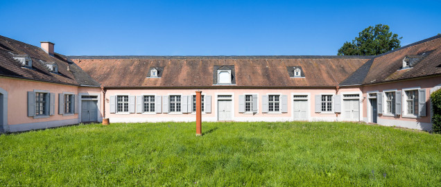 Schloss und Schlossgarten Schwetzingen - Garten - Invalidenkaserne (ehemaliges Baumagazin) - Westflügel / Innenhof - Von Osten - Blick nach Westen auf die Ostfassade des Westflügels (genutzt als Ausstellungsraum von xylon) sowie in den abgeschlossenen Innenhof; links ein Teil des Südflügels (genutzt von xylon), rechts ein Teil des Nordflügels (genutzt als Werkstattsraum von xylon) (Vierflügelanlage: Länge x Breite: ca. 60 x 50 Meter; Westflügel: ca. 50 x 10 Meter; Bauzeit: um 1774; Architekt des Baummagazins: Nicolas de Pigage; Umbau zur Kaserne: Ingenieur-Oberst von Pfister) (aufgenommen im Juni 2024, am Vormittag) Schloss und Schlossgarten Schwetzingen - Garten - Invalidenkaserne (ehemaliges Baumagazin) - Westflügel / Innenhof - Von Osten - Blick nach Westen auf die Ostfassade des Westflügels (genutzt als Ausstellungsraum von xylon) sowie in den abgeschlossenen Innenhof; links ein Teil des Südflügels (genutzt von xylon), rechts ein Teil des Nordflügels (genutzt als Werkstattsraum von xylon) (Vierflügelanlage: Länge x Breite: ca. 60 x 50 Meter; Westflügel: ca. 50 x 10 Meter; Bauzeit: um 1774; Architekt des Baummagazins: Nicolas de Pigage; Umbau zur Kaserne: Ingenieur-Oberst von Pfister) (aufgenommen im Juni 2024, am Vormittag)