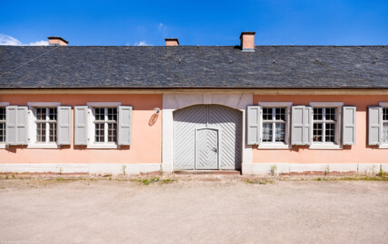 Schloss und Schlossgarten Schwetzingen - Garten - Invalidenkaserne (ehemaliges Baumagazin) - Südflügel - Von Süden - Blick auf den Toreingang zum Südflügel der Invalidenkaserne (Vierflügelanlage: Länge x Breite: ca. 60 x 50 Meter; Südflügel: ca. 60 x 10 Meter; Bauzeit: um 1774; Architekt des Baummagazins: Nicolas de Pigage; Umbau zur Kaserne: Ingenieur-Oberst von Pfister) (aufgenommen im Juni 2024, am späten Vormittag) Schloss und Schlossgarten Schwetzingen - Garten - Invalidenkaserne (ehemaliges Baumagazin) - Südflügel - Von Süden - Blick auf den Toreingang zum Südflügel der Invalidenkaserne (Vierflügelanlage: Länge x Breite: ca. 60 x 50 Meter; Südflügel: ca. 60 x 10 Meter; Bauzeit: um 1774; Architekt des Baummagazins: Nicolas de Pigage; Umbau zur Kaserne: Ingenieur-Oberst von Pfister) (aufgenommen im Juni 2024, am späten Vormittag)