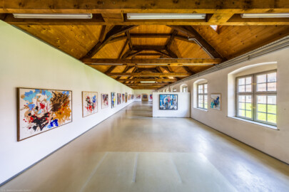 Schloss und Schlossgarten Schwetzingen - Garten - Invalidenkaserne (ehemaliges Baumagazin) / xylon - Museum + Werkstätten - Westflügel - Von innen - Von Süden - Blick nach Norden in die große Ausstellungshalle des Museums sowie nach oben in den Dachstuhl; hinter den Fenstern rechts liegt der Innenhof (Vierflügelanlage: Länge x Breite: ca. 60 x 50 Meter; Westflügel: ca. 50 x 10 Meter; Bauzeit: um 1774; Architekt des Baummagazins: Nicolas de Pigage; Umbau zur Kaserne: Ingenieur-Oberst von Pfister) (aufgenommen im Juni 2024, am frühen Nachmittag)