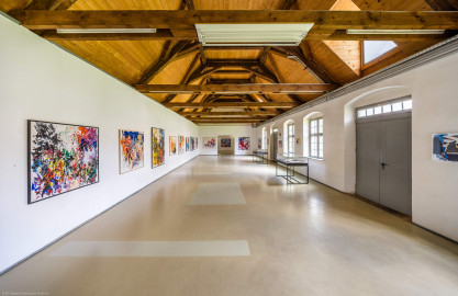 Schloss und Schlossgarten Schwetzingen - Garten - Invalidenkaserne (ehemaliges Baumagazin) / xylon - Museum + Werkstätten - Westflügel - Von innen - Von Süden - Blick nach Norden in einen Teil der großen Ausstellungshalle des Museums sowie nach oben in den Dachstuhl; hinter der Tür und den Fenstern rechts liegt der Innenhof (Vierflügelanlage: Länge x Breite: ca. 60 x 50 Meter; Westflügel: ca. 50 x 10 Meter; Bauzeit: um 1774; Architekt des Baummagazins: Nicolas de Pigage; Umbau zur Kaserne: Ingenieur-Oberst von Pfister) (aufgenommen im Juni 2024, am frühen Nachmittag) Schloss und Schlossgarten Schwetzingen - Garten - Invalidenkaserne (ehemaliges Baumagazin) / xylon - Museum + Werkstätten - Westflügel - Von innen - Von Süden - Blick nach Norden in einen Teil der großen Ausstellungshalle des Museums sowie nach oben in den Dachstuhl; hinter der Tür und den Fenstern rechts liegt der Innenhof (Vierflügelanlage: Länge x Breite: ca. 60 x 50 Meter; Westflügel: ca. 50 x 10 Meter; Bauzeit: um 1774; Architekt des Baummagazins: Nicolas de Pigage; Umbau zur Kaserne: Ingenieur-Oberst von Pfister) (aufgenommen im Juni 2024, am frühen Nachmittag)
