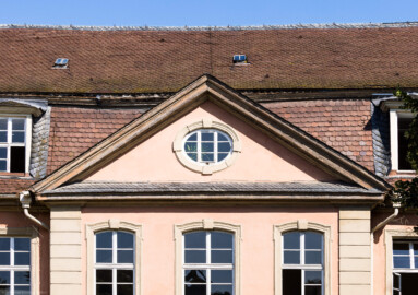 Schloss und Schlossgarten Schwetzingen - Garten - Gesandtenhaus (ehemaliges Prinzenhaus) / Amtsgericht - Von Südost - Blick auf den Dreiecksgiebel mit dem Ochsenauge oberhalb des Portals (Nutzung: Wohnungen für Angehörige der kurfürstlichen Familie, ausländische Besucher, Nicolas de Pigage (1723-1796), Friedrich Ludwig Skell (1750-1823), Johann Michael Zeyher (1770-1843), Sterbeort von Johann Peter Hebel (1760-1826), ab 1805 Amtsgericht) (Bau: Länge x Breite: ca. 40 x 17 Meter; Bauzeit: um 1723; Architekt: unbekannt) (aufgenommen im Juli 2024, am Vormittag)