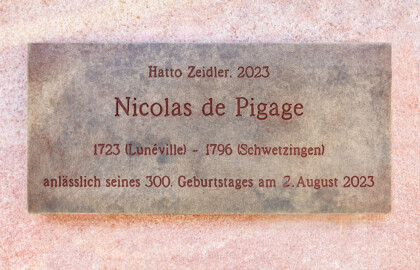 Schloss und Schlossgarten Schwetzingen - Außerhalb von Schloss und Garten - Schwetzingen - Pigage-Platz (beim Hotel Adler Post), Schlossstraße - Pigage-Denkmal - Tafel am Sandsteinsockel am Denkmal für Nicolas de Pigage (1723-1796) zur Erinnerung an seinen 300. Geburtstag (Bildhauer: Hatto Zeidler (*1938), Datierung: 2023, Einweihung: 22.07.2023) (aufgenommen im Juli 2024, um die Mittagszeit) Schloss und Schlossgarten Schwetzingen - Außerhalb von Schloss und Garten - Schwetzingen - Pigage-Platz (beim Hotel Adler Post), Schlossstraße - Pigage-Denkmal - Tafel am Sandsteinsockel am Denkmal für Nicolas de Pigage (1723-1796) zur Erinnerung an seinen 300. Geburtstag (Bildhauer: Hatto Zeidler (*1938), Datierung: 2023, Einweihung: 22.07.2023) (aufgenommen im Juli 2024, um die Mittagszeit)