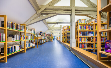 Schloss und Schlossgarten Schwetzingen - Garten - Invalidenkaserne (ehemaliges Baumagazin) / Stadtbibliothek  - Ostflügel - Von innen - Dachgeschoss - Von Nordwest - Blick nach Südost in den Bibliotheksraum (Vierflügelanlage: Länge x Breite: ca. 60 x 50 Meter; Ostflügel: ca. 60 x 10 Meter; Bauzeit: um 1774; Architekt des Baummagazins: Nicolas de Pigage; Umbau zur Kaserne: Ingenieur-Oberst von Pfister) (aufgenommen im Juli 2024, am frühen Nachmittag)