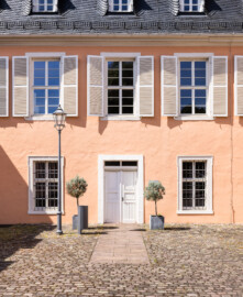 Schloss und Schlossgarten Schwetzingen - Schloss - Küchenflügel / Küchenbau -  Querbau - Von Osten - Blick auf den südlichen Eingang zum Querbau (Küchenflügel: L-förmig, Länge x Breite Längsbau ca. 75 x 13 Meter, Querbau ca. 25 x 11 Meter; Architekt: Nicolas de Pigage (1723-1796); Fertigstellung: 1761, letzte Renovierung: 2009-2012) (aufgenommen im August 2024, um die Mittagszeit)