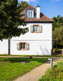 Schloss und Schlossgarten Schwetzingen - Schloss - Hochschule für Rechtspflege & Justizakademie - Studentenhaus - Von Nordost - Blick von der Bienenwiese auf die Ostseite des Studentenhauses; rechts der Leimbachkanal (Bau: Länge x Breite ca. 10 x 8 Meter; letzte Renovierung: 2009-2012) (aufgenommen im August 2024, um die Mittagszeit)