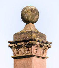 Schloss und Schlossgarten Schwetzingen - Schloss - Hof zwischen Südflügel und Küchenflügel - Gitterzaun, Südseite - Von Süden - Blick auf den oberen Abschluss eines Postaments der Balustrade, mit Kugel auf Sockel, darunter Akanthus-Ornamente (aufgenommen im August 2024, am Vormittag)