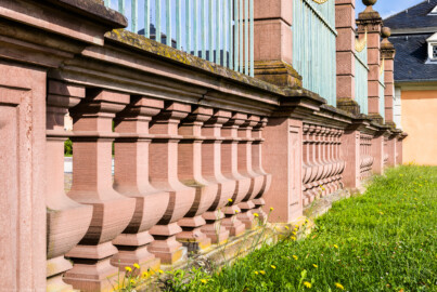 Schloss und Schlossgarten Schwetzingen - Schloss - Hof zwischen Südflügel und Küchenflügel - Gitterzaun, Ostseite - Von Süden - Blick auf die Balustrade auf der Ostseite des Hofs in Richtung südliches Wachthaus (aufgenommen im August 2024, am Vormittag)