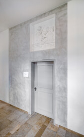 Schloss und Schlossgarten Schwetzingen - Schloss - Küchenflügel / Küchenbau - Längsbau - Von innen - Erdgeschoss - Gang / Hörsaal 3 - Von Nordwest - Blick auf den Eingangsbereich zum Hörsaal 3; Wandfläche um Tür ausgeführt in Stuccolustro (glänzender Stuck, eine historische Spachteltechnik); oben im vertieftem Wandfeld ein Stuckrelief (Küchenflügel: L-förmig, Länge x Breite Längsbau ca. 75 x 13 Meter, Querbau ca. 25 x 11 Meter; Architekt: Nicolas de Pigage (1723-1796); Fertigstellung: 1761, letzte Renovierung: 2009-2012) (aufgenommen im August 2024, am späten Vormittag) Schloss und Schlossgarten Schwetzingen - Schloss - Küchenflügel / Küchenbau - Längsbau - Von innen - Erdgeschoss - Gang / Hörsaal 3 - Von Nordwest - Blick auf den Eingangsbereich zum Hörsaal 3; Wandfläche um Tür ausgeführt in Stuccolustro (glänzender Stuck, eine historische Spachteltechnik); oben im vertieftem Wandfeld ein Stuckrelief (Küchenflügel: L-förmig, Länge x Breite Längsbau ca. 75 x 13 Meter, Querbau ca. 25 x 11 Meter; Architekt: Nicolas de Pigage (1723-1796); Fertigstellung: 1761, letzte Renovierung: 2009-2012) (aufgenommen im August 2024, am späten Vormittag)