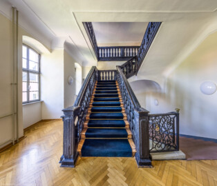 Schloss und Schlossgarten Schwetzingen - Garten - Gesandtenhaus (ehemaliges Prinzenhaus) / Amtsgericht - Von Innen - Treppenhaus / Obergeschoss - Von Norden - Zentraler Blick auf die barocke Holztreppe vom Obergeschoss ins Dachgeschoss; rechts die Steintreppe ins Erdgeschoss mit dem barocken schmiedeeisernen Treppengeländer (aufgenommen im August 2024, am späten Nachmittag)