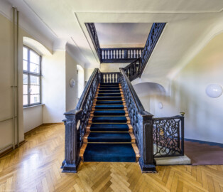 Schloss und Schlossgarten Schwetzingen - Garten - Gesandtenhaus (ehemaliges Prinzenhaus) / Amtsgericht - Von Innen - Treppenhaus / Obergeschoss - Von Norden - Zentraler Blick auf die barocke Holztreppe vom Obergeschoss ins Dachgeschoss; rechts die Steintreppe ins Erdgeschoss mit dem barocken schmiedeeisernen Treppengeländer (aufgenommen im August 2024, am späten Nachmittag)