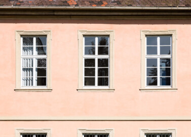 Schloss und Schlossgarten Schwetzingen - Garten - Gesandtenhaus (ehemaliges Prinzenhaus) / Amtsgericht - Von Südost -  Blick auf die drei mittleren südlichen Fenster im Obergeschoss (Nutzung: Wohnungen für Angehörige der kurfürstlichen Familie, ausländische Besucher, Nicolas de Pigage (1723-1796), Friedrich Ludwig Skell (1750-1823), Johann Michael Zeyher (1770-1843), Sterbeort von Johann Peter Hebel (1760-1826), ab 1805 Amtsgericht) (Bau: Länge x Breite: ca. 40 x 17 Meter; Bauzeit: um 1723; Architekt: unbekannt) (aufgenommen im August 2024, am späten Vormittag)