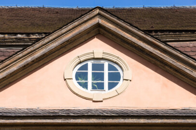 Schloss und Schlossgarten Schwetzingen - Garten - Gesandtenhaus (ehemaliges Prinzenhaus) / Amtsgericht - Von Südost - Blick auf den Dreiecksgiebel mit dem Ochsenauge oberhalb des Portals (Nutzung: Wohnungen für Angehörige der kurfürstlichen Familie, ausländische Besucher, Nicolas de Pigage (1723-1796), Friedrich Ludwig Skell (1750-1823), Johann Michael Zeyher (1770-1843), Sterbeort von Johann Peter Hebel (1760-1826), ab 1805 Amtsgericht) (Bau: Länge x Breite: ca. 40 x 17 Meter; Bauzeit: um 1723; Architekt: unbekannt) (aufgenommen im August 2024, am späten Vormittag)