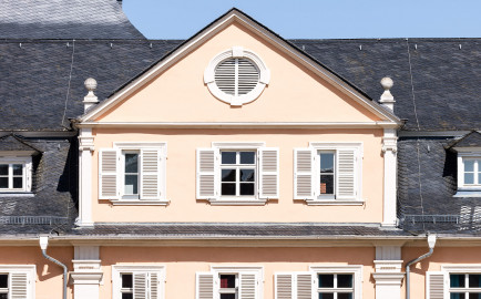 Schloss und Schlossgarten Schwetzingen - Schloss - Nordflügel / Hofkavaliersflügel - Längsbau - Mittelrisalit - Von Süden - Blick vom Obergeschoss des Südflügels nach Norden auf das Giebelfeld mit dem Ochsenauge und auf das Dachgeschoss des Mittelrisalits des Nordflügels; links der Mitte im Hintergrund das Dach des Oberen Wasserwerks (NordFlügel: L-förmig, Länge x Breite Längsbau ca. 50 x 14 Meter, Querbau ca. 15 x 12 Meter; Architekt: Johann Adam Breunig (1660-1727); Fertigstellung: 1710) (aufgenommen im August 2024, um die Mittagszeit) Schloss und Schlossgarten Schwetzingen - Schloss - Nordflügel / Hofkavaliersflügel - Längsbau - Mittelrisalit - Von Süden - Blick vom Obergeschoss des Südflügels nach Norden auf das Giebelfeld mit dem Ochsenauge und auf das Dachgeschoss des Mittelrisalits des Nordflügels; links der Mitte im Hintergrund das Dach des Oberen Wasserwerks (NordFlügel: L-förmig, Länge x Breite Längsbau ca. 50 x 14 Meter, Querbau ca. 15 x 12 Meter; Architekt: Johann Adam Breunig (1660-1727); Fertigstellung: 1710) (aufgenommen im August 2024, um die Mittagszeit)