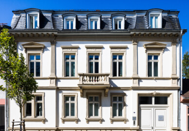 Schloss und Schlossgarten Schwetzingen - Schloss - Hochschule für Rechtspflege & Justizakademie - Verwaltungsbau - Von Osten - Blick von der Karlsruher Straße nach Westen auf die Ostfassade / die Eingangsseite des Verwaltungsbaus; oben am Torrahmen aus Sandstein die Inschrift "1870" (Verwaltungsbau: Länge x Breite ca. 15 x 15 Meter; letzte Renovierung: 2009-2012) (aufgenommen im August 2024, am späten Vormittag)