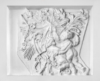Schloss und Schlossgarten Schwetzingen - Schloss - Küchenflügel / Küchenbau -  Längsbau - Von innen - Erdgeschoss - Gang - Westseite - 4. Stuckrelief von Osten / Durchgang zum Querbau - Von Osten - Blick auf ein Stuckrelief im vertieften Wandfeld mit zwei (spielenden? / tanzenden?) Putti (Bildhauer/Stuckateur und Datierung unbekannt) (Küchenflügel: L-förmig, Länge x Breite Längsbau ca. 75 x 13 Meter, Querbau ca. 25 x 11 Meter; Architekt: Nicolas de Pigage (1723-1796); Fertigstellung: 1761, letzte Renovierung: 2009-2012) (aufgenommen im September 2024, am frühen Nachmittag)