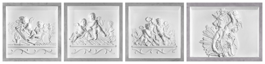 Schloss und Schlossgarten Schwetzingen - Schloss - Küchenflügel / Küchenbau -  Längsbau - Von innen - Erdgeschoss - Gang - Ostseite - 1. bis 4. Stuckrelief, von Westen aus gezählt - Blick auf die vier Stuckreliefs in den vertieften Wandfeldern mit je einem Putto oder zwei Putti (Bildhauer/Stuckateur und Datierung unbekannt; Ausnahme: drittes Stuckrelief von links: "Allegorie der Dichtkunst", Bildhauer/Stuckateur Hans Volker Dursy (1925-1991), Datierung: 1968, Darstellung in Anlehnung an eine Vase von Francesco Carabelli (1737-1798) beim Arionbrunnen) (Küchenflügel: L-förmig, Länge x Breite Längsbau ca. 75 x 13 Meter, Querbau ca. 25 x 11 Meter; Architekt: Nicolas de Pigage (1723-1796); Fertigstellung: 1761, letzte Renovierung: 2009-2012) (aufgenommen im September 2024)