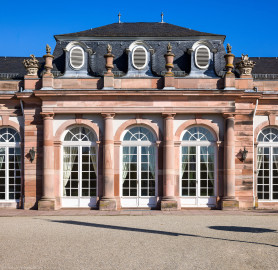 Schloss und Schlossgarten Schwetzingen - Garten - Nördlicher Zirkelbau - Mittlerer Pavillon - Von Südwest - Blick auf die Südwestfassade sowie auf das Gebälk und den Schmuck (Vasen und Blumenkörbe) (Gesamter Bau: Länge Bogen ca. 175 Meter, Breite zwischen ca. 11 und 18 Meter, 51 Achsen, 5 Pavillons, 4 Zwischenbauten; Architekt: Alessandro Alessandro Galli da Bibiena (1686-1748), Bauleitung: zuerst Guillaume d’Hauberat (1680–1749), dann Nicolas de Pigage (1723-1796); Bauzeit: 1748-1750) (aufgenommen im Oktober 2024, um die Mittagszeit) Schloss und Schlossgarten Schwetzingen - Garten - Nördlicher Zirkelbau - Mittlerer Pavillon - Von Südwest - Blick auf die Südwestfassade sowie auf das Gebälk und den Schmuck (Vasen und Blumenkörbe) (Gesamter Bau: Länge Bogen ca. 175 Meter, Breite zwischen ca. 11 und 18 Meter, 51 Achsen, 5 Pavillons, 4 Zwischenbauten; Architekt: Alessandro Alessandro Galli da Bibiena (1686-1748), Bauleitung: zuerst Guillaume d’Hauberat (1680–1749), dann Nicolas de Pigage (1723-1796); Bauzeit: 1748-1750) (aufgenommen im Oktober 2024, um die Mittagszeit)