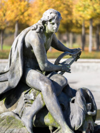 Schloss und Schlossgarten Schwetzingen - Garten - Kreisparterre - Arionbrunnen - Arion - Von Südost - Blick auf die die Skulptur "Arion auf einem Delfin" (Bildhauer: Barthélemy Guibal (1699-1757); Datierung: erste Hälfte 18. Jahrhundert; Material: Blei; geschaffen für die Sommerresidenz von Stanislaus I. Leszczyński (1677-1766) in Lunéville; gekauft 1766 von Carl Theodor (1724-1799, reg. 1742-1799)) (aufgenommen im Oktober 2024, am frühen Nachmittag)