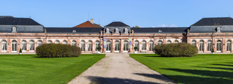 Schloss und Schlossgarten Schwetzingen - Garten - Nördlicher Zirkelbau - Von Südwest - Blick auf den zentralen Teil des nördlichen Zirkelbaus (Gesamter Bau: Länge Bogen ca. 175 Meter, Breite zwischen ca. 11 und 18 Meter, 51 Achsen, 5 Pavillons, 4 Zwischenbauten; Architekt: Alessandro Alessandro Galli da Bibiena (1686-1748), Bauleitung: zuerst Guillaume d’Hauberat (1680–1749), dann Nicolas de Pigage (1723-1796); Bauzeit: 1748-1750) (aufgenommen im Oktober 2024, am frühen Nachmittag)