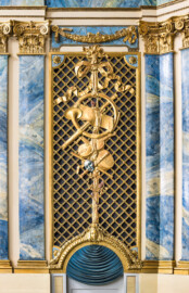 Schloss und Schlossgarten Schwetzingen - Garten - Schlosstheater - Von innen - Proszenium, Südseite - Blick auf den unteren Teil des südlichen Proszeniums (vom Parkett bis zum Rang); links und rechts ein Teil der kompositen Pilasterordnung, in der Mitte die Trompeterloge mit Musikinstrumenten (Flöten, Geige, Horn, Laute) und Notenblätter auf einem Gitterwerk sowie auf Girlanden, einem verschlungenen Band, einer Maske und weiteren Verzierungen, unten die Tür zum Orchestergraben (Gesamter Bau: Länge x Breite: ca. 62 x 35 Meter; Architekt: Nicolas de Pigage (1723-1796); Bauzeit: 1752-1753, Erweiterung 1762, Sanierung: 1937, Renovierung: 1952, Generalsanierung / Umbau 1971-1974, Restaurierung: 1999-2005) (aufgenommen im November 2024, am Nachmittag) Schloss und Schlossgarten Schwetzingen - Garten - Schlosstheater - Von innen - Proszenium, Südseite - Blick auf den unteren Teil des südlichen Proszeniums (vom Parkett bis zum Rang); links und rechts ein Teil der kompositen Pilasterordnung, in der Mitte die Trompeterloge mit Musikinstrumenten (Flöten, Geige, Horn, Laute) und Notenblätter auf einem Gitterwerk sowie auf Girlanden, einem verschlungenen Band, einer Maske und weiteren Verzierungen, unten die Tür zum Orchestergraben (Gesamter Bau: Länge x Breite: ca. 62 x 35 Meter; Architekt: Nicolas de Pigage (1723-1796); Bauzeit: 1752-1753, Erweiterung 1762, Sanierung: 1937, Renovierung: 1952, Generalsanierung / Umbau 1971-1974, Restaurierung: 1999-2005) (aufgenommen im November 2024, am Nachmittag)