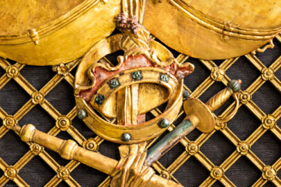 Schloss und Schlossgarten Schwetzingen - Garten - Schlosstheater - Von innen - Proszenium, Nordseite - Blick auf einen Teil der Trompeterloge mit Musikinstrumenten (ein Paar Pauken, Tamburin, Schalmei), einer Krone und einem Degen auf einem Gitterwerk sowie auf ein verschlungenen Band und weiteren Verzierungen (Gesamter Bau: Länge x Breite: ca. 62 x 35 Meter; Architekt: Nicolas de Pigage (1723-1796); Bauzeit: 1752-1753, Erweiterung 1762, Sanierung: 1937, Renovierung: 1952, Generalsanierung / Umbau 1971-1974, Restaurierung: 1999-2005) (aufgenommen im Dezember 2024, am späten Vormittag) Schloss und Schlossgarten Schwetzingen - Garten - Schlosstheater - Von innen - Proszenium, Nordseite - Blick auf einen Teil der Trompeterloge mit Musikinstrumenten (ein Paar Pauken, Tamburin, Schalmei), einer Krone und einem Degen auf einem Gitterwerk sowie auf ein verschlungenen Band und weiteren Verzierungen (Gesamter Bau: Länge x Breite: ca. 62 x 35 Meter; Architekt: Nicolas de Pigage (1723-1796); Bauzeit: 1752-1753, Erweiterung 1762, Sanierung: 1937, Renovierung: 1952, Generalsanierung / Umbau 1971-1974, Restaurierung: 1999-2005) (aufgenommen im Dezember 2024, am späten Vormittag)