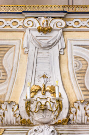 Schloss und Schlossgarten Schwetzingen - Garten - Schlosstheater - Von innen - Balkon, südwestlichste Loge - Von Norden - Blick vom Parkett auf eine balusterartige Blende mit Voluten, Tuchgehänge und Muschel an der gewölbten Brüstung der Loge; unten ein Fries mit Akanthusblättern, oben ein Fries aus Kreisen  (Gesamter Bau: Länge x Breite: ca. 62 x 35 Meter; Architekt: Nicolas de Pigage (1723-1796); Bauzeit: 1752-1753, Erweiterung 1762, Sanierung: 1937, Renovierung: 1952, Generalsanierung / Umbau 1971-1974, Restaurierung: 1999-2005) (aufgenommen im Dezember 2024, am Nachmittag)