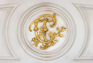 Schloss und Schlossgarten Schwetzingen - Garten - Nördlicher Zirkelbau - Westlicher Pavillon / Foyer des Schlosstheaters - Von innen - Nordwand, Mitte - Blick auf den oberen Teil der Eingangstür zum Schlosstheater mit dem Monogramm "CT" (Carl Theodor) (Gesamter Bau: Länge Bogen ca. 175 Meter, Breite zwischen ca. 11 und 18 Meter, 51 Achsen, 5 Pavillons, 4 Zwischenbauten; Architekt: Alessandro Alessandro Galli da Bibiena (1686-1748), Bauleitung: zuerst Guillaume d’Hauberat (1680–1749), dann Nicolas de Pigage (1723-1796); Bauzeit: 1748-1750) (aufgenommen im Januar 2025, am Nachmittag) Schloss und Schlossgarten Schwetzingen - Garten - Nördlicher Zirkelbau - Westlicher Pavillon / Foyer des Schlosstheaters - Von innen - Nordwand, Mitte - Blick auf den oberen Teil der Eingangstür zum Schlosstheater mit dem Monogramm "CT" (Carl Theodor) (Gesamter Bau: Länge Bogen ca. 175 Meter, Breite zwischen ca. 11 und 18 Meter, 51 Achsen, 5 Pavillons, 4 Zwischenbauten; Architekt: Alessandro Alessandro Galli da Bibiena (1686-1748), Bauleitung: zuerst Guillaume d’Hauberat (1680–1749), dann Nicolas de Pigage (1723-1796); Bauzeit: 1748-1750) (aufgenommen im Januar 2025, am Nachmittag)