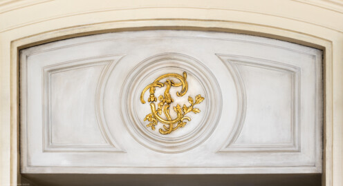 Schloss und Schlossgarten Schwetzingen - Garten - Nördlicher Zirkelbau - Westlicher Pavillon / Foyer des Schlosstheaters - Von innen - Nordwand, Mitte - Blick auf den oberen Teil der Eingangstür zum Schlosstheater mit dem Monogramm "CT" (Carl Theodor) (Gesamter Bau: Länge Bogen ca. 175 Meter, Breite zwischen ca. 11 und 18 Meter, 51 Achsen, 5 Pavillons, 4 Zwischenbauten; Architekt: Alessandro Alessandro Galli da Bibiena (1686-1748), Bauleitung: zuerst Guillaume d’Hauberat (1680–1749), dann Nicolas de Pigage (1723-1796); Bauzeit: 1748-1750) (aufgenommen im Januar 2025, am Nachmittag)