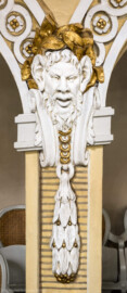 Schloss und Schlossgarten Schwetzingen - Garten - Schlosstheater - Von innen - Balkon, Nordseite - Von Süden - Blick von der Balkonbrüstung auf eine Rangstütze mit einer Faunsmaske als Schmuck; Modell für die Masken erstellt von Peter Anton von Verschaffelt (1710-1793) (Gesamter Bau: Länge x Breite: ca. 62 x 35 Meter; Architekt: Nicolas de Pigage (1723-1796); Bauzeit: 1752-1753, Erweiterung 1762, Sanierung: 1937, Renovierung: 1952, Generalsanierung / Umbau 1971-1974, Restaurierung: 1999-2005) (aufgenommen im Januar 2025, am Nachmittag)