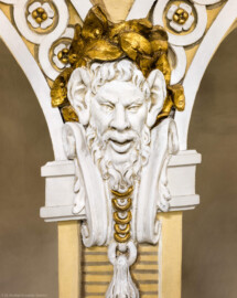 Schloss und Schlossgarten Schwetzingen - Garten - Schlosstheater - Von innen - Balkon, Nordseite - Von Süden - Blick von der Balkonbrüstung auf eine Rangstütze mit einer Faunsmaske als Schmuck; Modell für die Masken erstellt von Peter Anton von Verschaffelt (1710-1793) (Gesamter Bau: Länge x Breite: ca. 62 x 35 Meter; Architekt: Nicolas de Pigage (1723-1796); Bauzeit: 1752-1753, Erweiterung 1762, Sanierung: 1937, Renovierung: 1952, Generalsanierung / Umbau 1971-1974, Restaurierung: 1999-2005) (aufgenommen im Januar 2025, am Nachmittag)