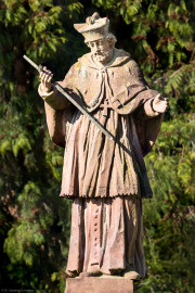 Schloss und Schlossgarten Schwetzingen - Schloss - Nahe dem Ehrenhof - Grünstreifen zwischen östlichem Ehrenhof und Leimbach - Nordostecke - Von Osten - Blick auf die Statue des Heiligen Nepomuk; die Inschrift des (nicht sichtbaren) Sockels lautet: "S. IOHANN VON NEPOMUCK / VON WENCELS WUTH BEKRIEGET / HAST AUFF DER PRAGER BRÜCK / DURCH SHWEIGEN OBSIEGET / ZUM SIEGES DENCKMAL HIER / THUT SHWETZINGEN AUFRICHTEN / DEIN BILDNIS UND SICH DIR / ZUR DIENERSCHAFT VERPFLICHTET / 1751" (zu Johannes (von) Nepomuk (um 1350-1393): böhmischer Priester und Märtyrer, 1729 heiliggesprochen, seit 1732 zweiter Ordenspatron der Jesuiten, Brückenheiliger und Patron des Beichtgeheimnisses) (Statue ist eine Kopie, angefertigt 1927 und 1968 an diesem Ort aufgestellt; Original im Museum der Stadt Schwetzingen; Original wohl aus der Werkstatt des Hofbildhauers Paul Johann Egell (1691-1752), Datierung 1751) (aufgenommen im April 2025, am späten Vormittag) Schloss und Schlossgarten Schwetzingen - Schloss - Nahe dem Ehrenhof - Grünstreifen zwischen östlichem Ehrenhof und Leimbach - Nordostecke - Von Osten - Blick auf die Statue des Heiligen Nepomuk; die Inschrift des (nicht sichtbaren) Sockels lautet: "S. IOHANN VON NEPOMUCK / VON WENCELS WUTH BEKRIEGET / HAST AUFF DER PRAGER BRÜCK / DURCH SHWEIGEN OBSIEGET / ZUM SIEGES DENCKMAL HIER / THUT SHWETZINGEN AUFRICHTEN / DEIN BILDNIS UND SICH DIR / ZUR DIENERSCHAFT VERPFLICHTET / 1751" (zu Johannes (von) Nepomuk (um 1350-1393): böhmischer Priester und Märtyrer, 1729 heiliggesprochen, seit 1732 zweiter Ordenspatron der Jesuiten, Brückenheiliger und Patron des Beichtgeheimnisses) (Statue ist eine Kopie, angefertigt 1927 und 1968 an diesem Ort aufgestellt; Original im Museum der Stadt Schwetzingen; Original wohl aus der Werkstatt des Hofbildhauers Paul Johann Egell (1691-1752), Datierung 1751) (aufgenommen im April 2025, am späten Vormittag)