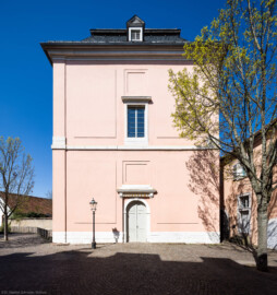 Schloss und Schlossgarten Schwetzingen - Sonstige Bauten - Oberes Wasserwerk - Wasserturm - Von außen - Von Süden - Blick von der Nordseite des Nordflügels / Hofkavaliersflügel  auf den Wasserturm des Oberen Wasserwerks; im Dachgeschoss in 18 Meter Höhe befanden sich zwei Wasserbehälter aus Blei, im Obergeschoss in 10 Meter Höhe zwei kleinere Reservoirs  (Gesamte Anlage Brunnenstube, Pumpenstube, Räderwerk, Wasserturm und Kühlhaus): Länge x Breite: ca. 30 x 29 Meter, Wasserturm: Länge x Breite: ca. 14 x 14 Meter, Firsthöhe ca. 24 Meter; Bauzeit Anlage: um 1774, Gesamtinstandsetzung: 1994–2000; Architekt: Nicolas de Pigage, Brunnenmeister: Thomas Breuer) (aufgenommen im April 2025, am Nachmittag)