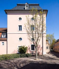 Schloss und Schlossgarten Schwetzingen - Sonstige Bauten - Oberes Wasserwerk - Wasserturm - Von außen - Von Westen - Blick von der Zeyherstraße nach Osten auf den Wasserturm des Oberen Wasserwerks; im Dachgeschoss in 18 Meter Höhe befanden sich zwei Wasserbehälter aus Blei, im Obergeschoss in 10 Meter Höhe zwei kleinere Reservoirs  (Gesamte Anlage Brunnenstube, Pumpenstube, Räderwerk, Wasserturm und Kühlhaus): Länge x Breite: ca. 30 x 29 Meter, Wasserturm: Länge x Breite: ca. 14 x 14 Meter, Firsthöhe ca. 24 Meter; Bauzeit Anlage: um 1774, Gesamtinstandsetzung: 1994–2000; Architekt: Nicolas de Pigage, Brunnenmeister: Thomas Breuer) (aufgenommen im April 2025, am Nachmittag)