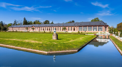 Schloss und Schlossgarten Schwetzingen - Garten - Orangeriegarten - Von Südost - Blick von der Südostecke des Orangeriegartens nach Nordwest auf Kanal, den Orangeriegarten und die Neue Orangerie (aufgenommen im April 2025, am frühen Nachmittag)