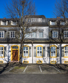 Schloss und Schlossgarten Schwetzingen - Sonstige Bauten - Palais Ysenburg (Forsthausstraße 7 und 9) - Von Nordwest - Blick von der Mauer zum Betriebshof in der Forsthausstraße nach Osten auf die Mitte der Westseite des Palais Ysenburg (ehemalige Bewohner: Mitglieder des kurfürstlichen Hofstaats, Oberhofgärter Theodor van Wynder († 1777), bis 1778 Oberstjägermeister Graf Friedrich Wilhelm von Ysenburg-Birstein (1730-1804) und Ehefrau Caroline Gräfin von Parkstein (1762-1816), eine uneheliche Tochter von Kurfürst Carl Theodor, Oberstjägermeister Johann Theodor Maria Reichsgraf v. Waldkirch (1720–1802), Oberforstmeister Friedrich Heinrich Georg Freiherr von Drais (1758-1833), ab 1864 der Industrielle Gustav Bassermann und Ehefrau Clementine; nach 1918 Kauf durch Stadt Schwetzingen, seit 1997 in Privatbesitz) (Bau: L-formig; Länge x Breite: Nordflügel ca. 34 x 7 Meter, Westflügel ca. 21 x 13 Meter, Westflügel mit Anbau bis zum Alten Forstamt ca. 48 x 10 Meter; Geschosse: 2 (inkl. Mansardgeschoss); Bauzeiten: 1760, Verbindung zum Alten Forstamt 1775, erweitert Ende des 19. Jh., restauriert 1997; Architekt: wohl Franz Wilhelm Rabaliatti (1714–1782)) (aufgenommen im April 2025, am späten Nachmittag) Schloss und Schlossgarten Schwetzingen - Sonstige Bauten - Palais Ysenburg (Forsthausstraße 7 und 9) - Von Nordwest - Blick von der Mauer zum Betriebshof in der Forsthausstraße nach Osten auf die Mitte der Westseite des Palais Ysenburg (ehemalige Bewohner: Mitglieder des kurfürstlichen Hofstaats, Oberhofgärter Theodor van Wynder († 1777), bis 1778 Oberstjägermeister Graf Friedrich Wilhelm von Ysenburg-Birstein (1730-1804) und Ehefrau Caroline Gräfin von Parkstein (1762-1816), eine uneheliche Tochter von Kurfürst Carl Theodor, Oberstjägermeister Johann Theodor Maria Reichsgraf v. Waldkirch (1720–1802), Oberforstmeister Friedrich Heinrich Georg Freiherr von Drais (1758-1833), ab 1864 der Industrielle Gustav Bassermann und Ehefrau Clementine; nach 1918 Kauf durch Stadt Schwetzingen, seit 1997 in Privatbesitz) (Bau: L-formig; Länge x Breite: Nordflügel ca. 34 x 7 Meter, Westflügel ca. 21 x 13 Meter, Westflügel mit Anbau bis zum Alten Forstamt ca. 48 x 10 Meter; Geschosse: 2 (inkl. Mansardgeschoss); Bauzeiten: 1760, Verbindung zum Alten Forstamt 1775, erweitert Ende des 19. Jh., restauriert 1997; Architekt: wohl Franz Wilhelm Rabaliatti (1714–1782)) (aufgenommen im April 2025, am späten Nachmittag)