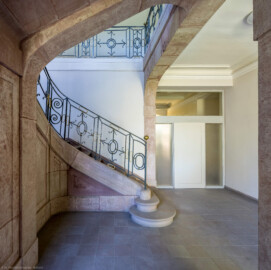 Schloss und Schlossgarten Schwetzingen - Sonstige Bauten - Altes Forstamt (Forsthausstraße 11) - Von innen - Treppenhaus - Erdgeschoss - Von Osten - Blick nach Westen auf die Treppe aus Sandstein mit dem schmiedeeisernen Geländer; links hinter der Sandsteinmauer der Abgang zum Keller; rechts der Durchgang in den westlichen Teil des Erdgeschosses (Bau: Länge x Breite: ca. 22 x 14 Meter; Geschosse: 2; Fensterachsen: 7; Bauzeit: 1760; erbaut als Haus des kurfürstlichen Oberjägermeisters; Verbindung mit dem Palais Ysenburg: 1775; Architekt: unbekannt) (aufgenommen im April 2025, am frühen Nachmittag)