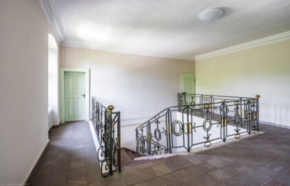 Schloss und Schlossgarten Schwetzingen - Sonstige Bauten - Altes Forstamt (Forsthausstraße 11) - Von innen - Treppenhaus - Obergeschoss - Von Nordost - Blick nach Südwest in das Treppenhaus und auf die Treppe aus Sandstein mit dem schmiedeeisernen Geländer; die Tür links führt in eine Wohnung, die Tür rechts in den Speicher bzw. den Dachstuhl (Bau: Länge x Breite: ca. 22 x 14 Meter; Geschosse: 2; Fensterachsen: 7; Bauzeit: 1760; erbaut als Haus des kurfürstlichen Oberjägermeisters; Verbindung mit dem Palais Ysenburg: 1775; Architekt: unbekannt) (aufgenommen im Juni 2025, am späten Nachmittag)