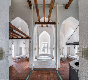 Schloss und Schlossgarten Schwetzingen - Sonstige Bauten - Oberes Wasserwerk - Wasserturm - Von innen - Obergeschoss / Cafeteria / Kantine - Von Norden - Zentraler Blick von der Tür zum Dachstuhl des sog. Reißbodens nach Süden in den Raum; Wände und mittige Pfeiler sind "gotisch" bzw. spitzbogenartig gestaltet; rechts die Theke der Cafeteria, links eine kleine Zwischenebene, die zum Dachstuhl über zwei Eisenleitern führt; rechts und links der mittleren Pfeiler vier Leitungen (Steigleitungen? / Fallleitungen?) von der Brunnenstube zu den Wasserbehältern im Dachgeschoss; eiserne Anker in den Wänden und Pfeilern und Holzbalken dienten wohl als Zwischenebenen zur Lagerung (Gesamte Anlage (Brunnenhaus, Pumpenhaus, Räderwerk, Wasserturm, Reißboden, Werkstatt und Wohnung Brunnenmeister): Länge x Breite: ca. 35 x 35 Meter, Wasserturm: Länge x Breite: ca. 14 x 14 Meter, Firsthöhe ca. 24 Meter; Bauzeit Anlage: um 1774; Architekt: Nicolas de Pigage, Brunnenmeister: Thomas Breuer) (aufgenommen im Juni 2025, um die Mittagszeit) Schloss und Schlossgarten Schwetzingen - Sonstige Bauten - Oberes Wasserwerk - Wasserturm - Von innen - Obergeschoss / Cafeteria / Kantine - Von Norden - Zentraler Blick von der Tür zum Dachstuhl des sog. Reißbodens nach Süden in den Raum; Wände und mittige Pfeiler sind "gotisch" bzw. spitzbogenartig gestaltet; rechts die Theke der Cafeteria, links eine kleine Zwischenebene, die zum Dachstuhl über zwei Eisenleitern führt; rechts und links der mittleren Pfeiler vier Leitungen (Steigleitungen? / Fallleitungen?) von der Brunnenstube zu den Wasserbehältern im Dachgeschoss; eiserne Anker in den Wänden und Pfeilern und Holzbalken dienten wohl als Zwischenebenen zur Lagerung (Gesamte Anlage (Brunnenhaus, Pumpenhaus, Räderwerk, Wasserturm, Reißboden, Werkstatt und Wohnung Brunnenmeister): Länge x Breite: ca. 35 x 35 Meter, Wasserturm: Länge x Breite: ca. 14 x 14 Meter, Firsthöhe ca. 24 Meter; Bauzeit Anlage: um 1774; Architekt: Nicolas de Pigage, Brunnenmeister: Thomas Breuer) (aufgenommen im Juni 2025, um die Mittagszeit)