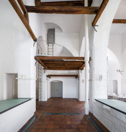Schloss und Schlossgarten Schwetzingen - Sonstige Bauten - Oberes Wasserwerk - Wasserturm - Von innen - Obergeschoss / Cafeteria / Kantine - Von Westen - Blick von der Theke der Cafeteria nach Osten auf den Eingangsbereich; Wände und mittige Pfeiler sind "gotisch" bzw. spitzbogenartig gestaltet; das Gitter aus Balken in der Bildmitte ist eine kleine Zwischenebene zum Aufstieg in den Dachstuhl über Eisenleitern; rechts eine der vier Leitungen (Steigleitung? / Fallleitung?) von der Brunnenstube zu den Wasserbehältern im Dachgeschoss; eiserne Anker in den Pfeilern und Holzbalken dienten wohl als Zwischenebenen zur Lagerung (Gesamte Anlage (Brunnenhaus, Pumpenhaus, Räderwerk, Wasserturm, Reißboden, Werkstatt und Wohnung Brunnenmeister): Länge x Breite: ca. 35 x 35 Meter, Wasserturm: Länge x Breite: ca. 14 x 14 Meter, Firsthöhe ca. 24 Meter; Bauzeit Anlage: um 1774; Architekt: Nicolas de Pigage, Brunnenmeister: Thomas Breuer) (aufgenommen im Juni 2025, am Nachmittag) Schloss und Schlossgarten Schwetzingen - Sonstige Bauten - Oberes Wasserwerk - Wasserturm - Von innen - Obergeschoss / Cafeteria / Kantine - Von Westen - Blick von der Theke der Cafeteria nach Osten auf den Eingangsbereich; Wände und mittige Pfeiler sind "gotisch" bzw. spitzbogenartig gestaltet; das Gitter aus Balken in der Bildmitte ist eine kleine Zwischenebene zum Aufstieg in den Dachstuhl über Eisenleitern; rechts eine der vier Leitungen (Steigleitung? / Fallleitung?) von der Brunnenstube zu den Wasserbehältern im Dachgeschoss; eiserne Anker in den Pfeilern und Holzbalken dienten wohl als Zwischenebenen zur Lagerung (Gesamte Anlage (Brunnenhaus, Pumpenhaus, Räderwerk, Wasserturm, Reißboden, Werkstatt und Wohnung Brunnenmeister): Länge x Breite: ca. 35 x 35 Meter, Wasserturm: Länge x Breite: ca. 14 x 14 Meter, Firsthöhe ca. 24 Meter; Bauzeit Anlage: um 1774; Architekt: Nicolas de Pigage, Brunnenmeister: Thomas Breuer) (aufgenommen im Juni 2025, am Nachmittag)