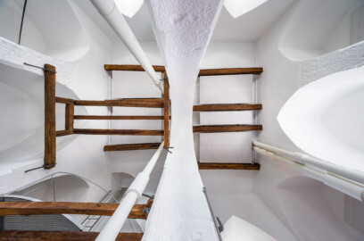 Schloss und Schlossgarten Schwetzingen - Sonstige Bauten - Oberes Wasserwerk - Wasserturm - Von innen - Obergeschoss / Cafeteria / Kantine - Nach oben - Blick vom Zentrum des Raumes nach oben; links ist Norden, unten ist Osten; Wände und mittige Pfeiler sind "gotisch" bzw. spitzbogenartig gestaltet; das Gitter aus Balken links unten ist eine kleine Zwischenebene zum Aufstieg in den Dachstuhl über Eisenleitern; mittig oben und unten sowie rechts unten vier Leitungen (Steigleitungen? / Fallleitungen?) von der Brunnenstube zu den Wasserbehältern im Dachgeschoss; eiserne Anker in den Pfeilern und Holzbalken dienten wohl als Zwischenebenen zur Lagerung (Gesamte Anlage (Brunnenhaus, Pumpenhaus, Räderwerk, Wasserturm, Reißboden, Werkstatt und Wohnung Brunnenmeister): Länge x Breite: ca. 35 x 35 Meter, Wasserturm: Länge x Breite: ca. 14 x 14 Meter, Firsthöhe ca. 24 Meter; Bauzeit Anlage: um 1774; Architekt: Nicolas de Pigage, Brunnenmeister: Thomas Breuer) (aufgenommen im Juni 2025, am Nachmittag) Schloss und Schlossgarten Schwetzingen - Sonstige Bauten - Oberes Wasserwerk - Wasserturm - Von innen - Obergeschoss / Cafeteria / Kantine - Nach oben - Blick vom Zentrum des Raumes nach oben; links ist Norden, unten ist Osten; Wände und mittige Pfeiler sind "gotisch" bzw. spitzbogenartig gestaltet; das Gitter aus Balken links unten ist eine kleine Zwischenebene zum Aufstieg in den Dachstuhl über Eisenleitern; mittig oben und unten sowie rechts unten vier Leitungen (Steigleitungen? / Fallleitungen?) von der Brunnenstube zu den Wasserbehältern im Dachgeschoss; eiserne Anker in den Pfeilern und Holzbalken dienten wohl als Zwischenebenen zur Lagerung (Gesamte Anlage (Brunnenhaus, Pumpenhaus, Räderwerk, Wasserturm, Reißboden, Werkstatt und Wohnung Brunnenmeister): Länge x Breite: ca. 35 x 35 Meter, Wasserturm: Länge x Breite: ca. 14 x 14 Meter, Firsthöhe ca. 24 Meter; Bauzeit Anlage: um 1774; Architekt: Nicolas de Pigage, Brunnenmeister: Thomas Breuer) (aufgenommen im Juni 2025, am Nachmittag)