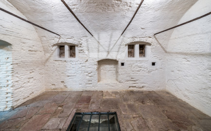 Schloss und Schlossgarten Schwetzingen - Sonstige Bauten - Oberes Wasserwerk - Kühlhaus - Von innen - Wildbretkeller - Von Osten - Blick nach Westen in den gewölbten Raum, links der Eingang; der Wildbretkeller diente dem Abhängen von Wild an den eisernen Stangen und zur Lagerung von Lebensmitteln; am Fußboden in der Mitte ein großes Loch, um den darunter liegenden zugangslosen Eiskeller mit Eisblöcken zu befüllen (Gesamte Anlage Brunnenstube, Pumpenstube, Räderwerk, Wasserturm und Kühlhaus): Länge x Breite: ca. 30 x 29 Meter, Kühlhaus: Länge x Breite: ca. 14 x 13 Meter, Firsthöhe ca. 14 Meter, Kellertiefe ca. 3 Meter; Bauzeit Anlage: um 1774, Gesamtinstandsetzung: 1994–2000; Architekt: Nicolas de Pigage, Brunnenmeister: Thomas Breuer) (aufgenommen im Juni 2025, am Nachmittag) Schloss und Schlossgarten Schwetzingen - Sonstige Bauten - Oberes Wasserwerk - Kühlhaus - Von innen - Wildbretkeller - Von Osten - Blick nach Westen in den gewölbten Raum, links der Eingang; der Wildbretkeller diente dem Abhängen von Wild an den eisernen Stangen und zur Lagerung von Lebensmitteln; am Fußboden in der Mitte ein großes Loch, um den darunter liegenden zugangslosen Eiskeller mit Eisblöcken zu befüllen (Gesamte Anlage Brunnenstube, Pumpenstube, Räderwerk, Wasserturm und Kühlhaus): Länge x Breite: ca. 30 x 29 Meter, Kühlhaus: Länge x Breite: ca. 14 x 13 Meter, Firsthöhe ca. 14 Meter, Kellertiefe ca. 3 Meter; Bauzeit Anlage: um 1774, Gesamtinstandsetzung: 1994–2000; Architekt: Nicolas de Pigage, Brunnenmeister: Thomas Breuer) (aufgenommen im Juni 2025, am Nachmittag)